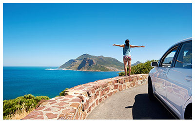 Image of woman on vacation with rental car.