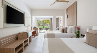 Image of two beds in a room leading to a balcony.