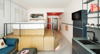 Photo of hotel room with elevated bed and seating/eating area.