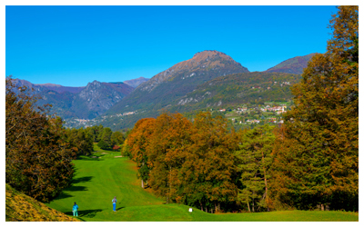 Golf green with mountains in the background.