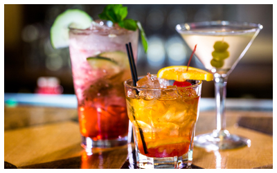 Three cocktails on a bar.